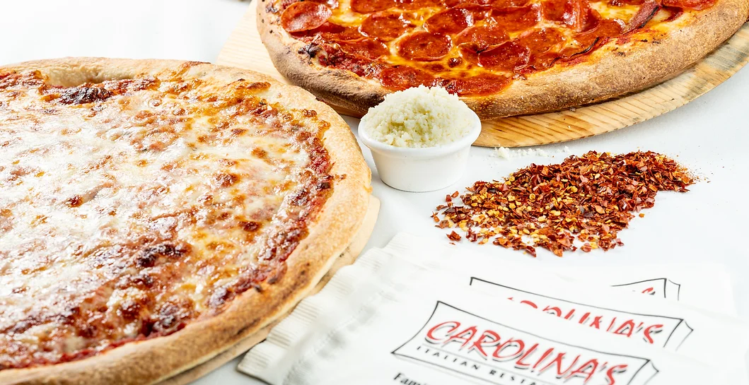 A couple of pizzas are on the table A couple of pizzas are on the table